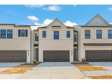 Attractive townhouse exteriors showcase neutral color palette and attached garages at 1945 Westwind Street (Lot 162), Lawrenceville, GA 30043