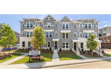 Charming townhomes featuring gray siding, white accents, well-maintained landscaping and sidewalk at 111 Chestnut Trce # 9, Hapeville, GA 30354