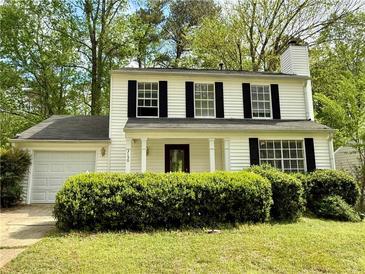 Charming two-story home featuring black shutters, a chimney, manicured bushes and a one-car garage at 3150 Berkshire Manor Dr, Alpharetta, GA 30022
