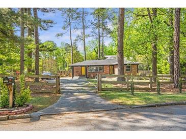 Charming brick home featuring a welcoming driveway and mature trees, creating a serene and private setting at 3385 Pinehill Dr, Decatur, GA 30032