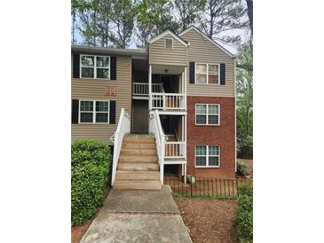 Exterior of condo with a brick facade and wooden stairs leading to second-floor units at 306 Teal Ct, Roswell, GA 30076