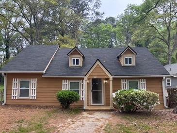 Charming single-story home featuring dormer windows, light-colored shutters and tidy landscaping at 2523 Hood Nw Ave, Atlanta, GA 30318