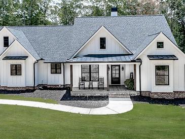 Charming white farmhouse with inviting porch and manicured lawn in a tranquil setting at 1170 Upper Sweetwater Se Trl, White, GA 30184