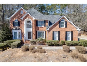 Beautiful two-story brick home featuring a well-manicured front yard and classic architectural details at 395 Highland Gate Cir, Suwanee, GA 30024