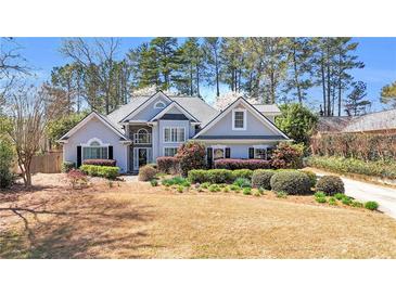 Charming home with lush landscaping, flowering trees, and a well-maintained front yard, creating a welcoming curb appeal at 4090 Cherry Ridge Walk, Suwanee, GA 30024