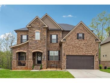 Charming two-story home showcasing a mixed brick and stone exterior with a well-manicured front lawn at 245 Piedmont Cir, Covington, GA 30016