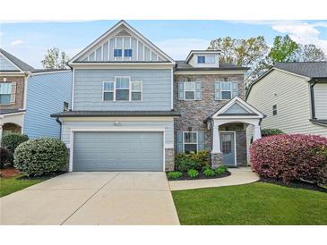 Charming two-story home with a two-car garage, stone accents, and beautiful landscaping at 3897 Lake Sanctuary Way, Atlanta, GA 30349