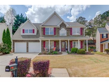 Charming two-story home with a well-manicured front yard, stone accents, red shutters and a welcoming front porch at 3904 Tristan Way, Suwanee, GA 30024