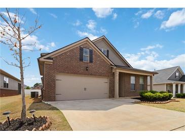 Charming brick home with a two-car garage and well-manicured lawn, enhanced by a bright blue sky at 558 Carleton Pl, Locust Grove, GA 30248