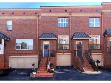 Brick townhome exterior featuring individual garages, stairs to front door, and classic architectural design at 62 Emerson Hill Sq, Marietta, GA 30060