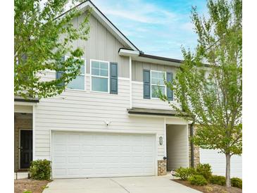 Charming townhome with a two-car garage and beautifully landscaped front yard for added curb appeal at 5522 Donerail St, Lithonia, GA 30058