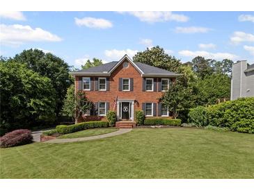 Charming two-story brick home with a well-manicured lawn and a welcoming front entrance at 1811 Tilliewood Ne Trl, Marietta, GA 30066