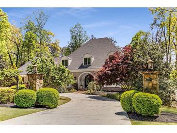 Stately home featuring beautiful landscaping, a circular driveway, and stone pillar light fixtures at 5780 Heards Forest Dr, Atlanta, GA 30328