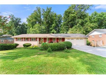 Charming single-story home with brick accents, attached garage, and a beautifully maintained lawn at 5666 Bob White Nw Cir, Lilburn, GA 30047