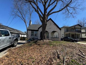 Charming brick home featuring arched porch, landscaped yard, and mature shade tree at 880 Westmont Sw Rd, Atlanta, GA 30311