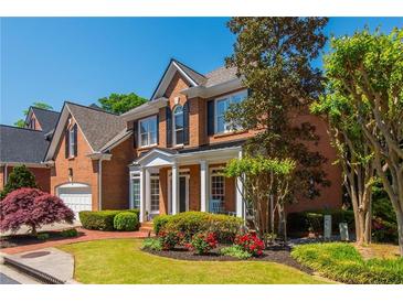 Charming two-story brick home with well-manicured lawn, red roses, and mature trees at 2296 Valley Brook Ne Way, Atlanta, GA 30319