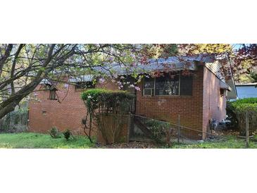 Charming brick home exterior with blossoming tree in the front yard at 102 Welch St, Stockbridge, GA 30281