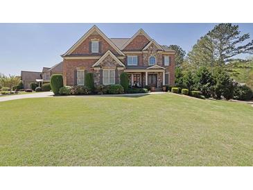 Beautiful brick home with stone accents and lush green lawn at 2450 Weber Heights Way, Buford, GA 30519