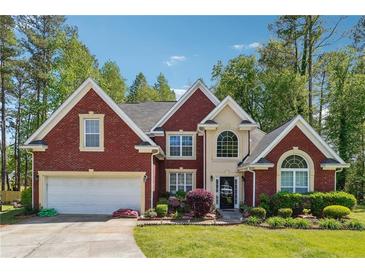 Charming two-story brick home featuring a well-manicured lawn and attached two-car garage at 3560 Glen Summit Ln, Snellville, GA 30039