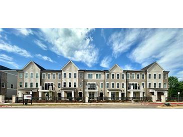 Charming new townhome community with craftsman-style architecture and lush landscaping against a blue sky at 556 Sawnee Village Blvd # D76, Cumming, GA 30040