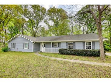 Charming single-story home with light-blue siding, a white front porch, and a well-maintained front yard at 806 Jefferson Sw Ct, Conyers, GA 30094