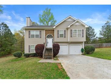 Charming two-story home with stone accents, attached garage, and landscaped front yard at 313 Daniel Mill Xing, Villa Rica, GA 30180