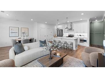 Bright, open-concept living room features a modern kitchen with stainless steel appliances and a cozy seating area at 554 Sawnee Village Blvd # D75, Cumming, GA 30040