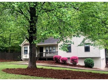 Charming home with a well-maintained front yard, mature tree, mulch bed, and a cozy front porch at 647 Sunshine Nw Trce, Acworth, GA 30102