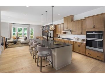 Modern kitchen features a large island with seating, stainless steel appliances, and an open floor plan at 1456 Wicker Wood Se Pl # 15, Smyrna, GA 30080