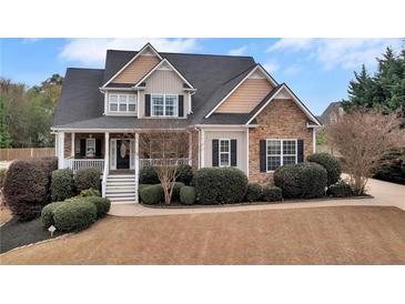 Charming two-story home featuring stone accents, a welcoming porch, and beautifully landscaped front yard at 52 Weatherstone Way, Dallas, GA 30157