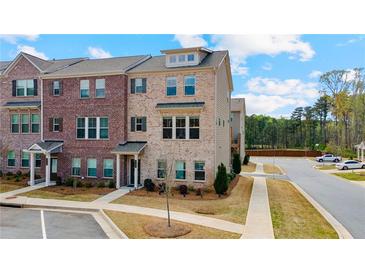 Two-story townhome featuring a brick facade, well-maintained landscaping, and convenient parking spaces at 3420 Reagan Way, Lawrenceville, GA 30044
