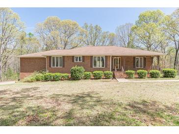 Charming brick home with a well-maintained lawn, mature trees, and inviting curb appeal at 452 Hightower Ridge Rd, Covington, GA 30014