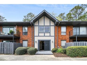 Attractive brick apartment building with dark trim and gray fence and attractive landscaping at 6851 Roswell Rd # A-12, Atlanta, GA 30328
