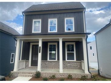 Charming two-story home featuring dark siding, white trim, a welcoming front porch, and beautiful landscaping at 2725 Creek View Nw Ter, Atlanta, GA 30318