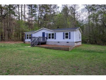 Charming single-story home with a blue front door and a well-maintained lawn at 643 Tumlin Lake Rd, Temple, GA 30179