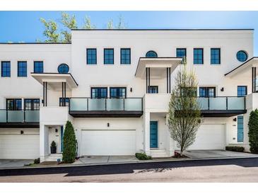 Modern townhome featuring white brick, private balconies, garage, and stylish architectural details at 1337 Grey Fox Ne Ct, Atlanta, GA 30306