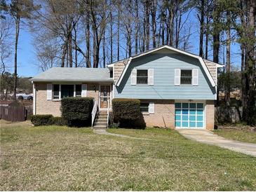 Charming split-level home with light blue siding and well-maintained front yard at 6675 Hidden Brook Trl, Atlanta, GA 30349