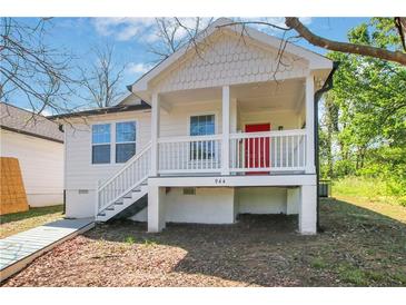 Charming cottage-style home with a red front door and elevated porch, perfect for enjoying the outdoors at 944 Joseph E Boone Nw Blvd, Atlanta, GA 30314