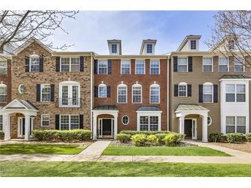 Charming brick townhome featuring black shutters, manicured landscaping, and inviting front entrances at 11265 Musette Cir, Alpharetta, GA 30009