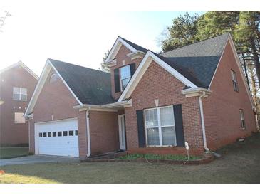 Charming brick home featuring a two-car garage and well-maintained landscaping at 1211 Liverpool Pointe, Lawrenceville, GA 30046
