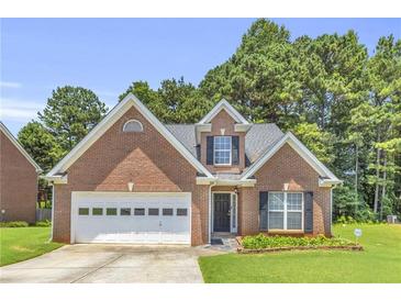 Charming single-story brick home with attached garage, landscaped yard, and lush green trees surrounding at 1211 Liverpool Pointe, Lawrenceville, GA 30046