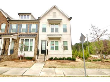 Charming brick townhome with a welcoming entrance, neat landscaping, and a sidewalk at 4209 Tifton Ln, Sugar Hill, GA 30518