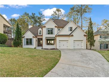 Charming two-story home with a manicured lawn and a two-car garage at 5485 Woodrun Ln, Johns Creek, GA 30005