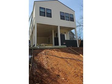 Modern two-story home with a light exterior, dark accents, and a unique elevated design, creating an inviting curb appeal at 996 Camilla St, Atlanta, GA 30314
