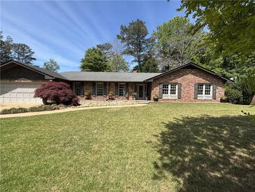 Charming one-story brick home featuring a well-manicured lawn and mature landscaping at 2112 Fisher Ne Trl, Atlanta, GA 30345