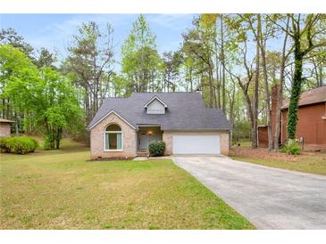 Charming single-Gathering home with well-manicured front yard, long driveway, and attached garage at 7275 Oswego Trl, Riverdale, GA 30296