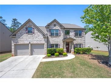 Charming two-story brick home with well-manicured lawn and attached two-car garage at 225 Mary Jane Ln, Covington, GA 30016