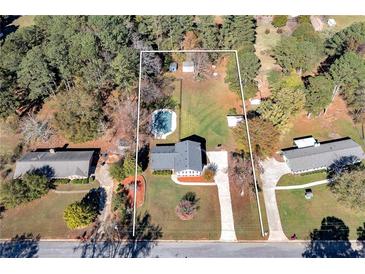 Sprawling property featuring a lovely in-ground pool and a charming home surrounded by lush trees and green space at 313 Fayette Villa Ct, Fayetteville, GA 30214