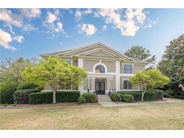 Charming two-story home with a manicured lawn, beautiful landscaping, and classic architectural details at 7415 Northampton Ct, Cumming, GA 30040