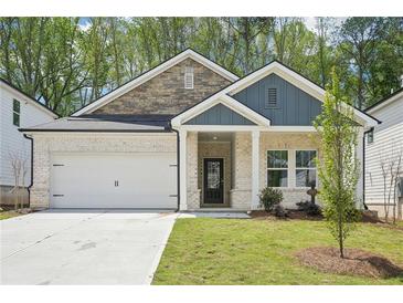 Charming single-story home with brick and stone accents, complemented by a well-manicured lawn and a two-car garage at 3953 Brushy St, Powder Springs, GA 30127